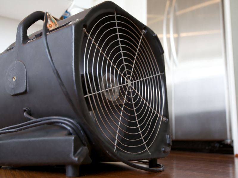Air mover fan drying hardwood floor after water damage restoration in Orlando FL